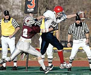 Zach Vredenburgh stretches for a first down as Eden's Pat Beckett reaches for the tackle during Sunday's game at the University of Rochester. Vredenburgh had a 29-yard interception return for a touchdown for Forks' first score.