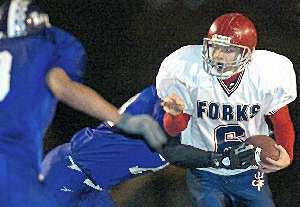 Forks quarterback Tim Batty works to escape the grasp of Norwich's Ray Gonzalez during the first quarter of Saturday's Class B title game at Binghamton Municipal Stadium